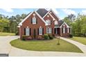 Charming brick home boasts black shutters, lush landscaping, and well-maintained grounds at 2351 Rabbit Farm Cir, Loganville, GA 30052