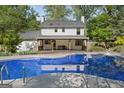 Back of house with a covered porch overlooking a spacious pool and backyard at 180 Paces Dr, Fayetteville, GA 30215