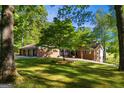 Charming brick home with attached garage, surrounded by a lush lawn and mature trees at 4383 Pool Rd, Winston, GA 30187