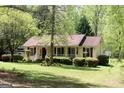 Inviting single-story home featuring a cozy front porch, American flag, and meticulously maintained landscaping at 206 Pine Cedar Cir, Brooks, GA 30205