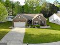 An elevated shot of a brick home with a manicured lawn and tree-lined streets at 327 Viceroy Curv, Stockbridge, GA 30281