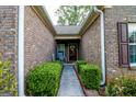 Inviting entryway with brick walls, manicured bushes, and a cozy porch with a rocking chair at 327 Viceroy Curv, Stockbridge, GA 30281