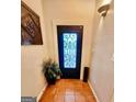 Bright foyer featuring neutral walls, terra-cotta tile flooring, and an ornate, glass-paneled front door at 144 Garden Walk, Stockbridge, GA 30281