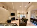 Cozy living room featuring a fireplace with a TV, natural lighting, and seamlessly connecting to the kitchen at 144 Garden Walk, Stockbridge, GA 30281