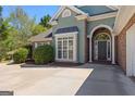 The elegant entryway features an arched doorway with decorative brickwork, flanked by white columns, adding charm to the home's exterior at 202 Willow Rock Pt, Fayetteville, GA 30215