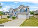Well-manicured home with gray siding, white trim, blue shutters, and attached two car garage at 736 Mesa Rd, Mcdonough, GA 30253