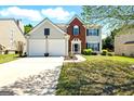 Two-story home with a well-manicured lawn, two-car garage, and combination brick and siding exterior at 340 Hammersmith Dr, Suwanee, GA 30024