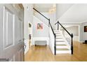 Inviting foyer with hardwood floors, a staircase, and a view into other living spaces at 340 Hammersmith Dr, Suwanee, GA 30024