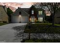 Inviting two-story home with a well-lit exterior, two-car garage, and a beautifully landscaped front yard at twilight at 340 Hammersmith Dr, Suwanee, GA 30024