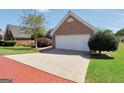 Brick home featuring an attached two-car garage, wide driveway, and well-maintained landscaping at 1313 Jubilee Ln, Mcdonough, GA 30253