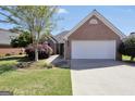 Charming brick home with an attached two-car garage, a well-manicured lawn and beautiful landscaping at 1313 Jubilee Ln, Mcdonough, GA 30253