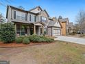 Inviting two-story home featuring a covered front porch and lush landscaping at 3541 Stoneleigh Walk, Lithonia, GA 30038