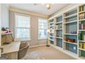 Bright bedroom with built-in bookshelves, a neutral color scheme, and natural light from two windows at 1535 Justine Se Way, Mableton, GA 30126