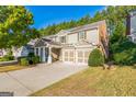 Charming two-story home showcasing a two-car garage and manicured lawn on a sunny day at 1535 Justine Se Way, Mableton, GA 30126