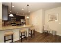 Open kitchen with granite countertops, dark cabinets, stainless appliances, and barstool seating at 316 Trulove Lane Lot 35 # 35, Locust Grove, GA 30248