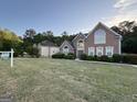 Beautiful two-story brick home featuring a well-manicured lawn and lush landscaping at 135 Danube Trl, Stockbridge, GA 30281