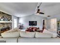 Spacious living room featuring a stone fireplace, vaulted ceilings, and an abundance of natural light at 2582 Rosecommons Dr, Hampton, GA 30228
