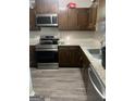 Well-lit kitchen features stainless steel appliances, wood cabinets and granite countertops at 1331 Woodstone Trce, Morrow, GA 30260