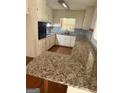 Bright kitchen with granite countertops, white cabinetry, and a functional layout at 5730 Koweta Rd, South Fulton, GA 30349