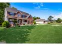 Sprawling green lawn complements this impressive two-story home with a brick facade and a welcoming front porch at 419 Tea Rose N Ln, Stockbridge, GA 30281