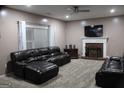 Spacious living room features plush leather seating, fireplace, ceiling fan, and natural light at 419 Tea Rose N Ln, Stockbridge, GA 30281