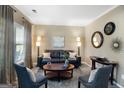 Cozy living room with a black leather sofa, stylish decor, and ample natural light from the large window at 419 Tea Rose N Ln, Stockbridge, GA 30281