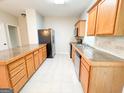 Well-lit kitchen featuring a stainless steel refrigerator and wooden cabinets at 33 Corinth Rd, Cartersville, GA 30121