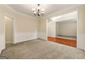 Formal dining area with elegant chandelier and neutral carpet adjacent to the foyer at 6281 Vinings Vintage Dr, Mableton, GA 30126