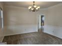 Spacious dining room featuring neutral carpet, chandelier, and a view into the kitchen at 6281 Vinings Vintage Dr, Mableton, GA 30126