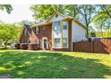 Beautiful home featuring a well-maintained lawn, mature trees, and classic architectural details at 310 Hamdon Kells, Peachtree City, GA 30269