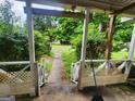 Cozy porch with seating area and view of the landscaped backyard and greenery at 30 Millwood Dr, Covington, GA 30016