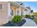 Inviting front porch enhanced by brick columns and meticulous landscaping details at 255 Orchid Dr, Mcdonough, GA 30252