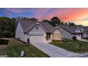 Beautiful single-Gathering home with a well-maintained lawn, two-car garage, and inviting entrance at sunset at 5910 Stellata Cir, Cumming, GA 30028