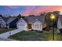Well-maintained single-Gathering home with a two-car garage, lush front lawn, and inviting entrance during twilight at 5910 Stellata Cir, Cumming, GA 30028