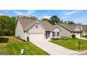 A well-maintained single-Gathering home with a two-car garage, lush green lawn, and inviting curb appeal at 5910 Stellata Cir, Cumming, GA 30028