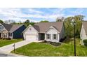 Beautiful gray home featuring a two-car garage, manicured lawn, and charming landscaping at 5910 Stellata Cir, Cumming, GA 30028