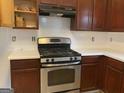 Kitchen featuring stainless steel appliances, dark wood cabinets, and new white countertops at 390 Hulan Way, Lawrenceville, GA 30044
