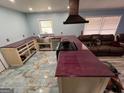 Unique kitchen with custom purple countertops, designer vent hood, and stainless sink at 98 Almon Church Rd, Covington, GA 30014