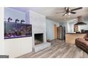 Open-concept living room with a brick fireplace, wood-look floors, and access to the kitchen at 98 Almon Church Rd, Covington, GA 30014