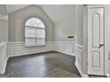 Living area with a vaulted ceiling, a large window, and classic white trim at 28 Willow Ridge Dr, Hampton, GA 30228