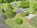 Expansive aerial view showcases brick home, verdant lawn, garden, and outbuildings at 39 Gabrielle Ct, Stockbridge, GA 30281