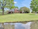 Beautiful two-story brick home with a large front lawn and picturesque pond view at 39 Gabrielle Ct, Stockbridge, GA 30281