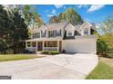 Traditional home with covered porch, stone accents, two-car garage, long driveway, and ample front yard at 3065 Willow Park Dr, Dacula, GA 30019