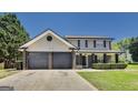 Two story home featuring a two-car garage and well maintained lawn at 200 Tait Rd, Stockbridge, GA 30281