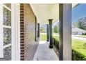Covered front porch featuring brick columns and a trimmed bush at 200 Tait Rd, Stockbridge, GA 30281