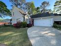Charming home featuring a two-car garage, red door and colorful landscaping at 411 Sherrels Frd, Peachtree City, GA 30269