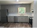 Bright kitchen featuring stainless steel appliances, wood floor, light gray cabinetry, and marble-style countertops at 30 Laurel Way, Covington, GA 30016