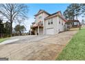 Exterior shot of home with a multi-level deck, driveway, and mature trees surrounding the property at 5141 Dixie Lake Rd, Union City, GA 30291