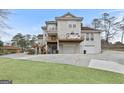 Exterior shot of home with a multi-level deck, driveway, and mature trees surrounding the property at 5141 Dixie Lake Rd, Union City, GA 30291