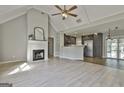 Bright open-concept living room featuring a fireplace, vaulted ceilings, and seamless kitchen access at 140 Pecan Ridge Dr, Fayetteville, GA 30215